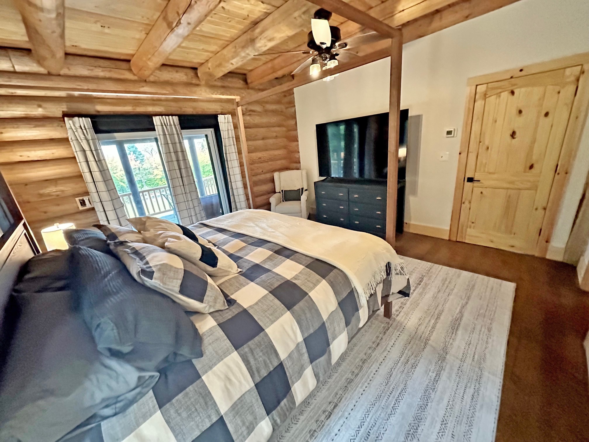 Cozy rustic bedroom with wooden beams and plaid bedding