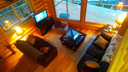 Cozy wooden cabin living room with sofas and warm lighting