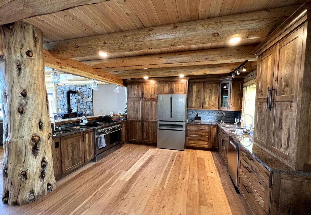 Modern kitchen featuring wooden cabinets, granite countertops, and stainless steel appliances with a rustic wooden beam design.