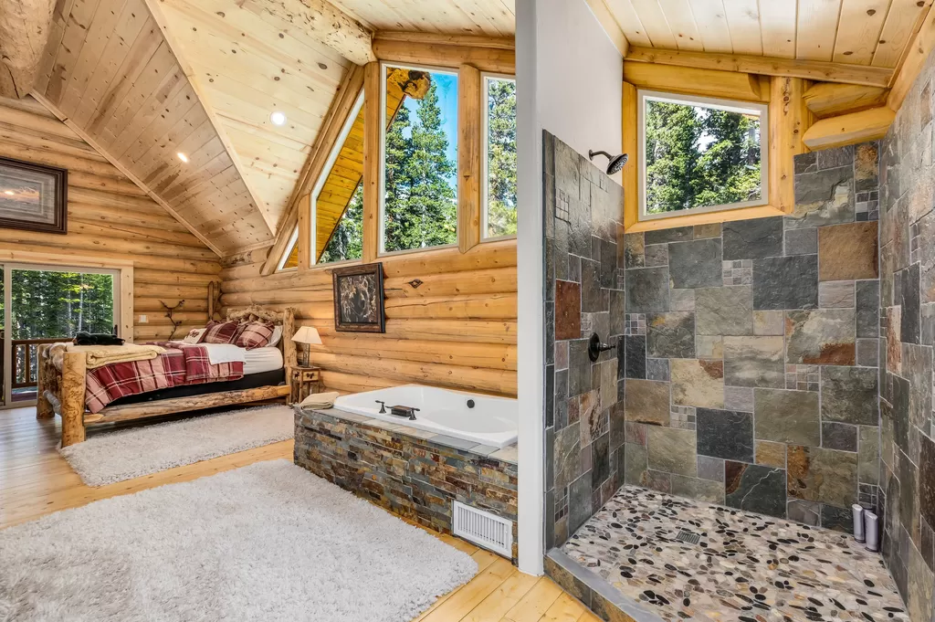 Rustic cabin bedroom with stone shower and wooden decor