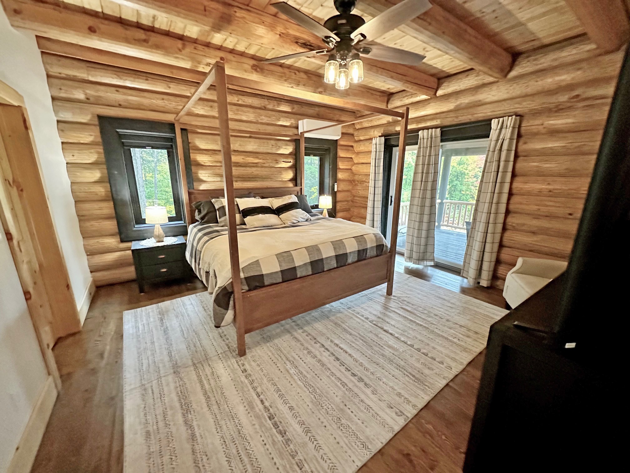 Cozy rustic bedroom with log walls and a wooden canopy bed
