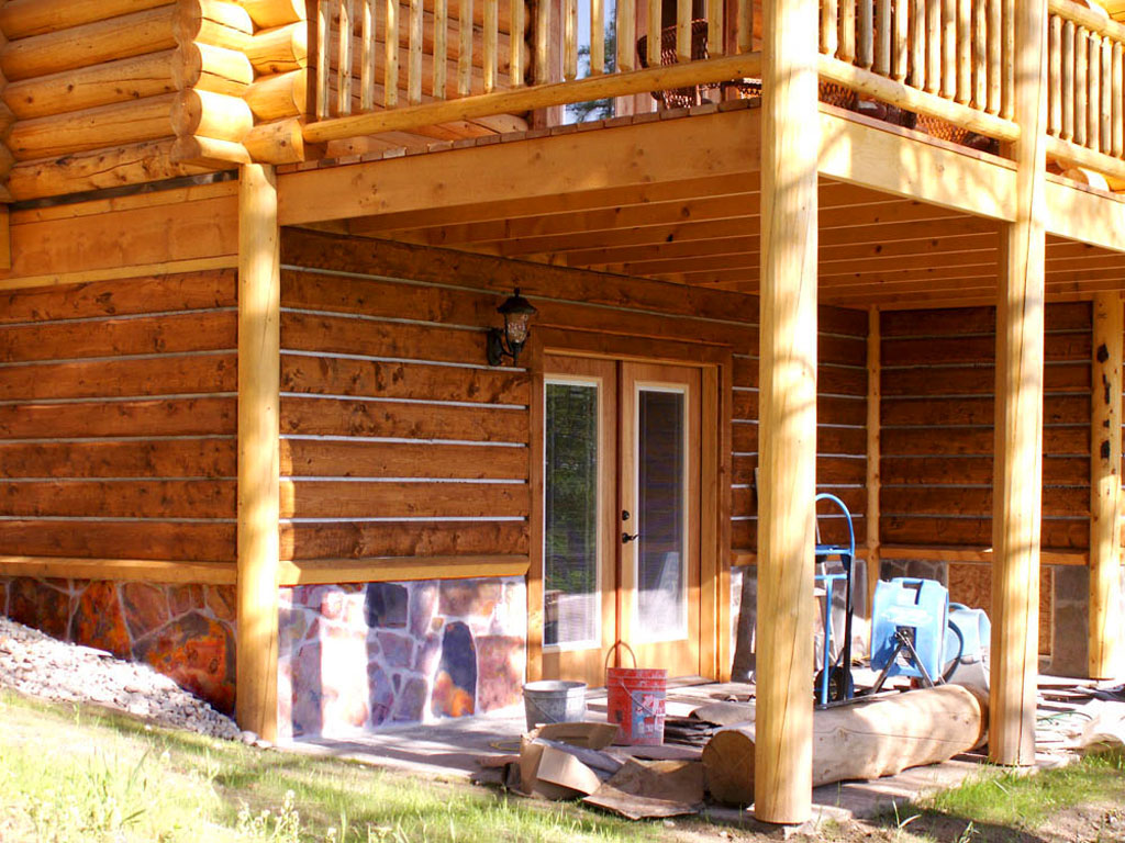Log cabin exterior with wooden porch and stone accents