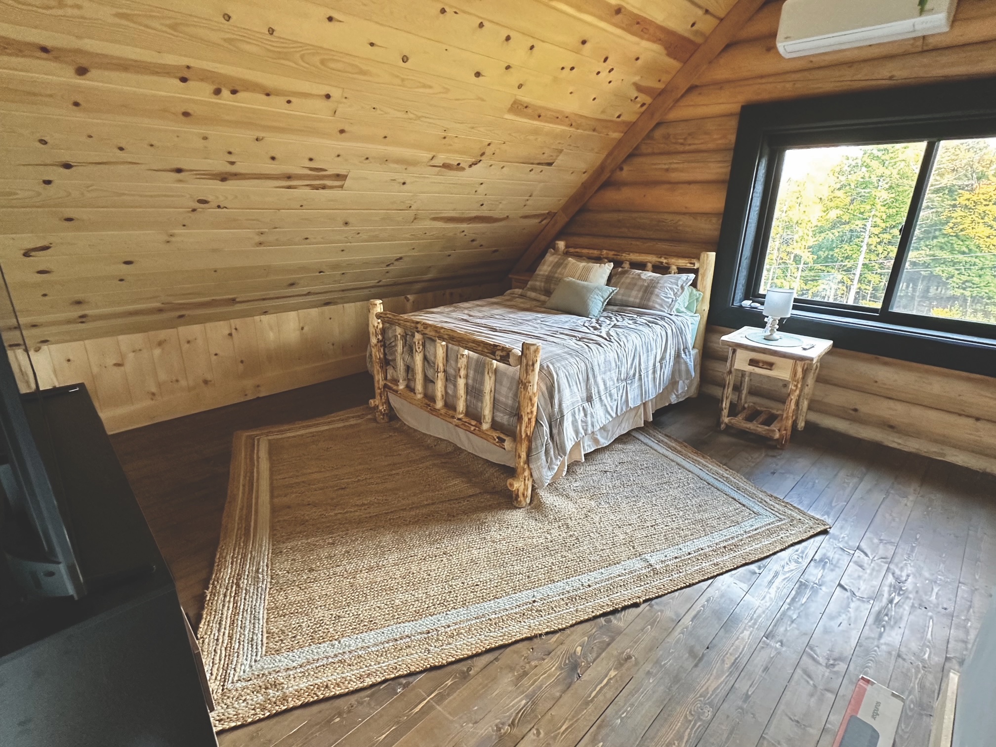 Cozy rustic bedroom with wooden accents and large window