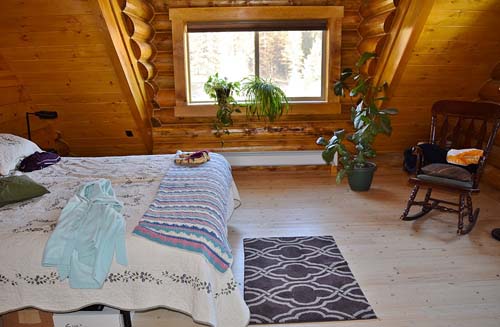 Loft bedroom with gable dormer inside looking out