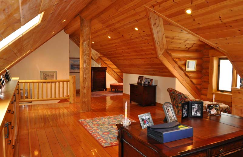 Spacious rustic attic office with wooden decor and lighting