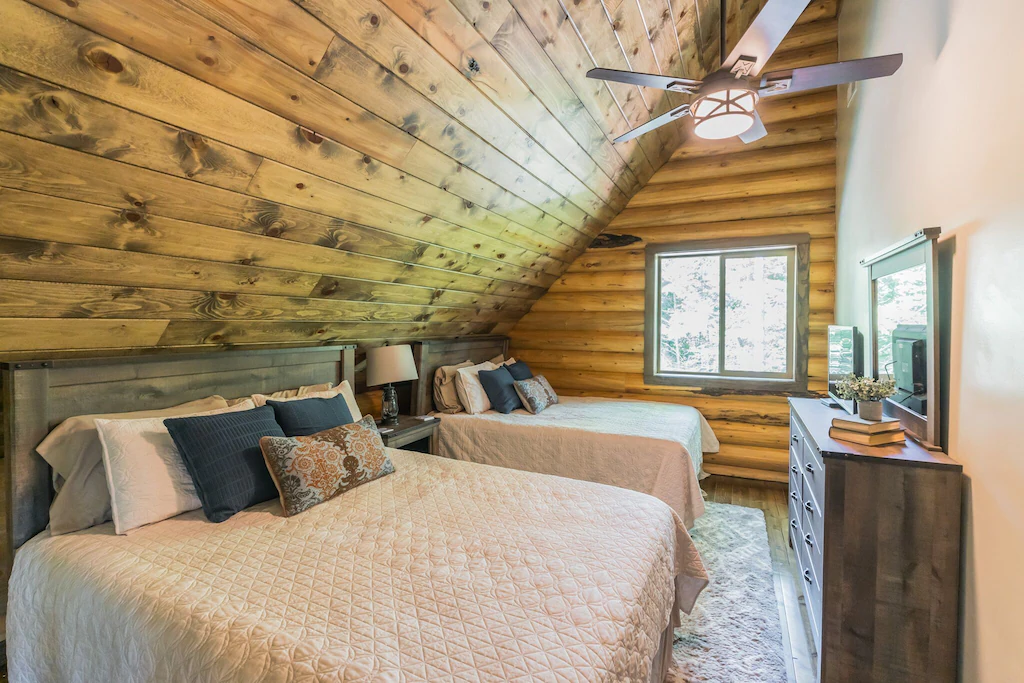 Cozy cabin bedroom with wooden walls and two double beds