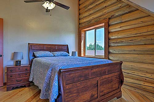 Rustic wooden cabin bedroom interior with cozy bed and window