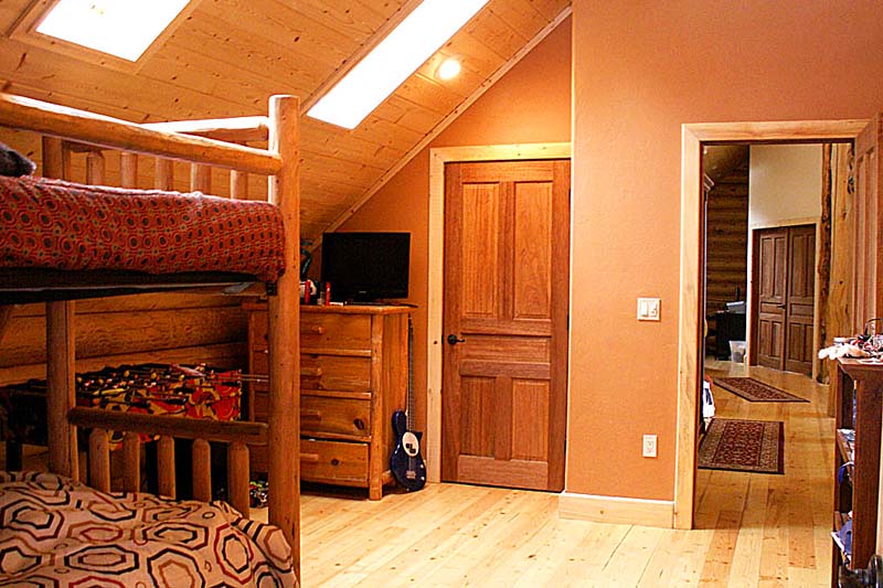 Cozy wooden attic bedroom with bunk beds and warm lighting