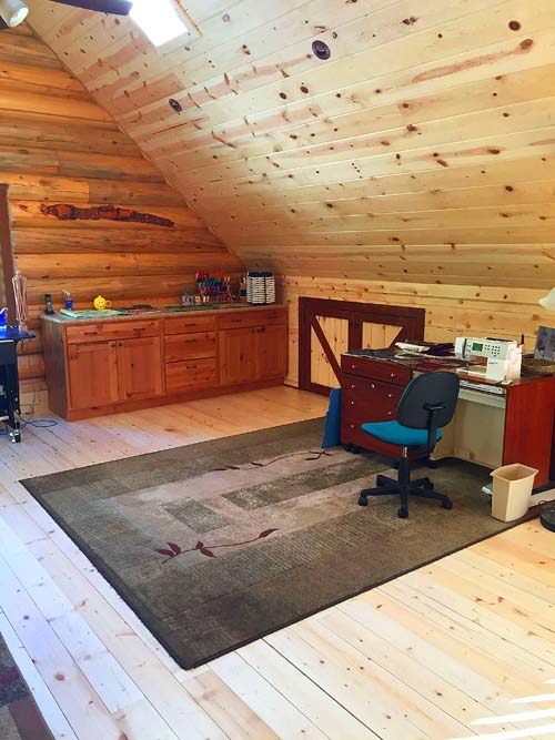 Rustic home office with wooden walls and sewing area