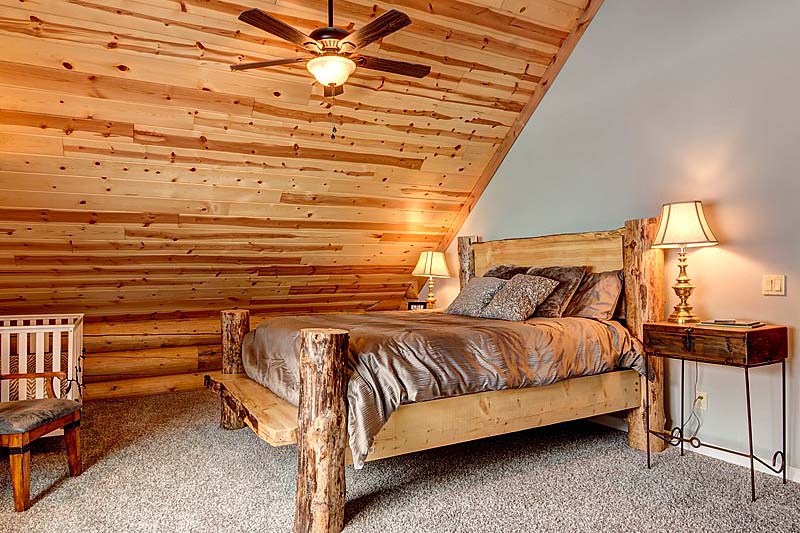 Cozy rustic bedroom with wooden ceiling and large bed