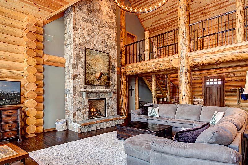 Rustic log cabin living room with stone fireplace and cozy sofa