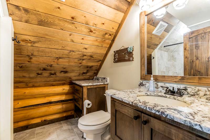 Rustic wood-paneled bathroom with modern fixtures and decor