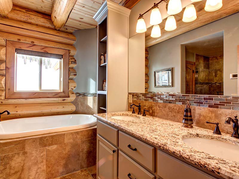A log home bathroom featuring a glass shower, a vintage-style freestanding tub, and wooden log walls. home master bath 2 800