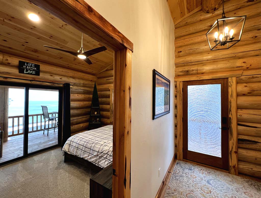 Cozy rustic cabin bedroom with wooden walls and balcony view
