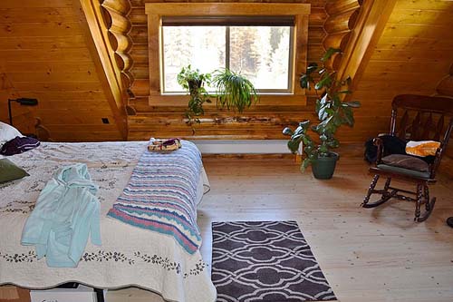Cozy cabin bedroom with wooden walls and a large window