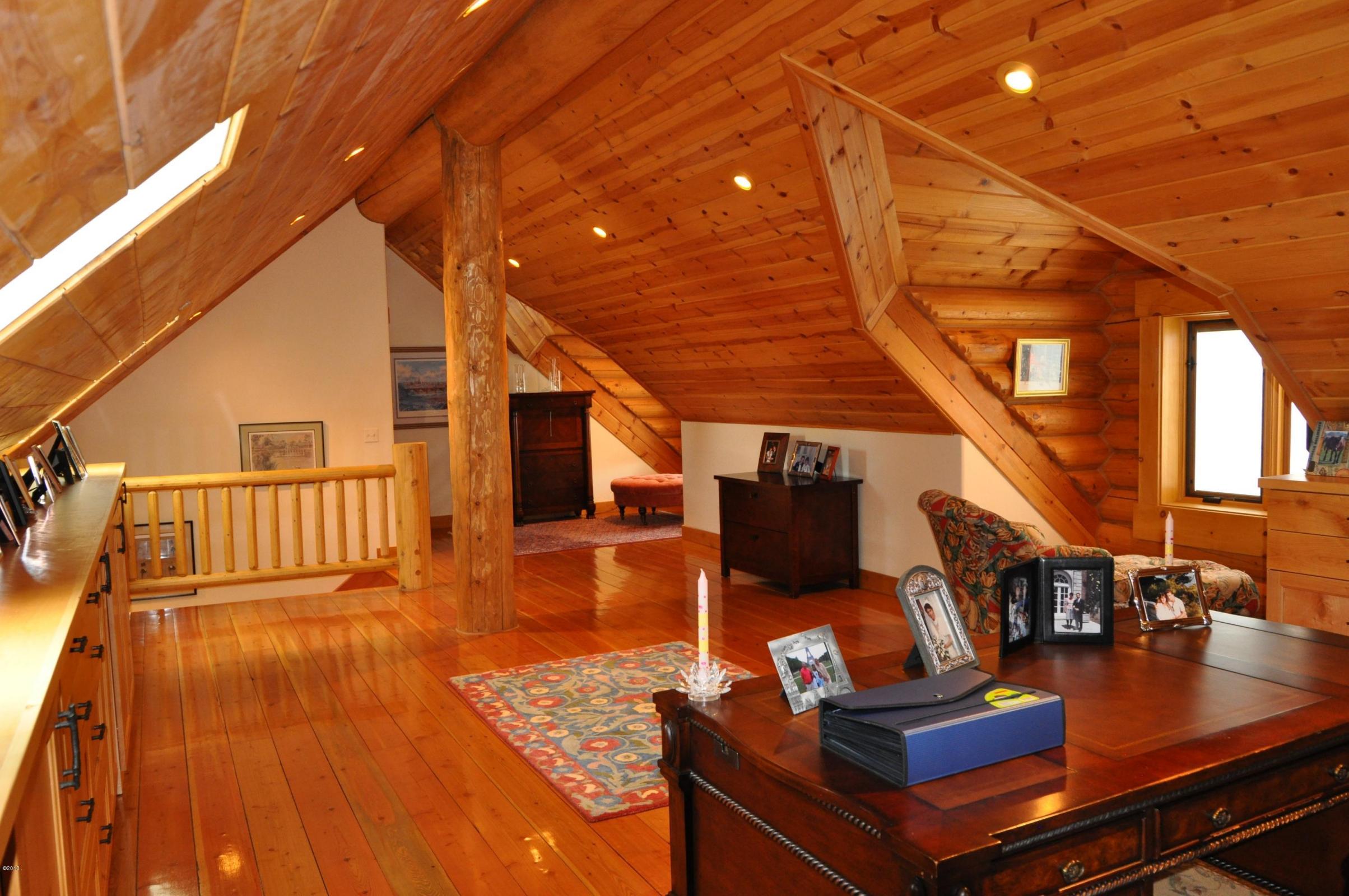 Spacious wooden attic with cozy seating and natural light