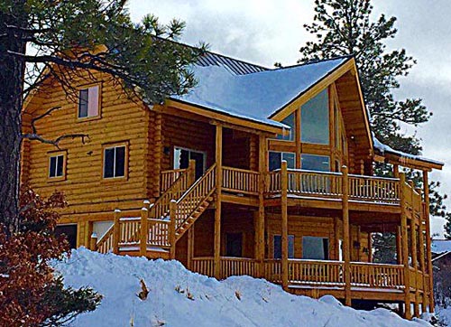 Wooden cabin surrounded by snow in a forest setting