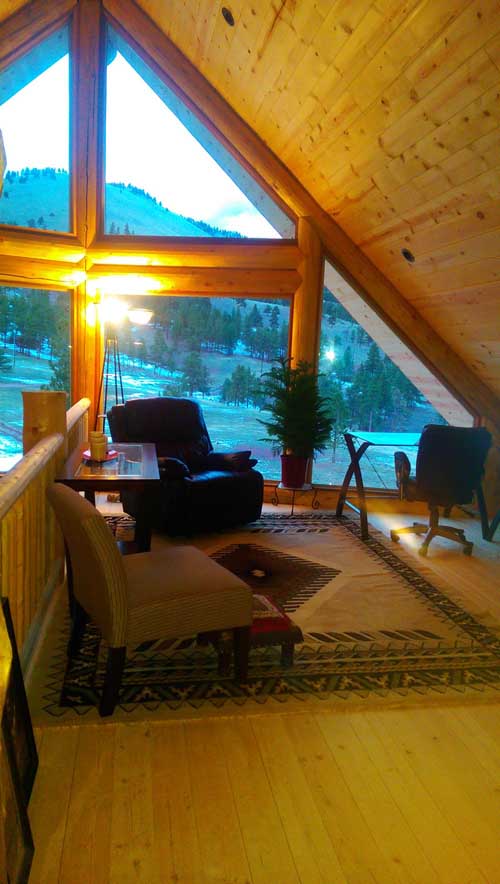 Cozy mountain chalet interior with large windows and seating