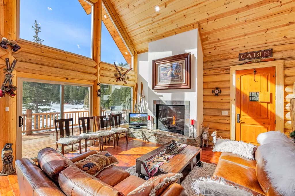 Cozy log cabin interior with fireplace and large windows
