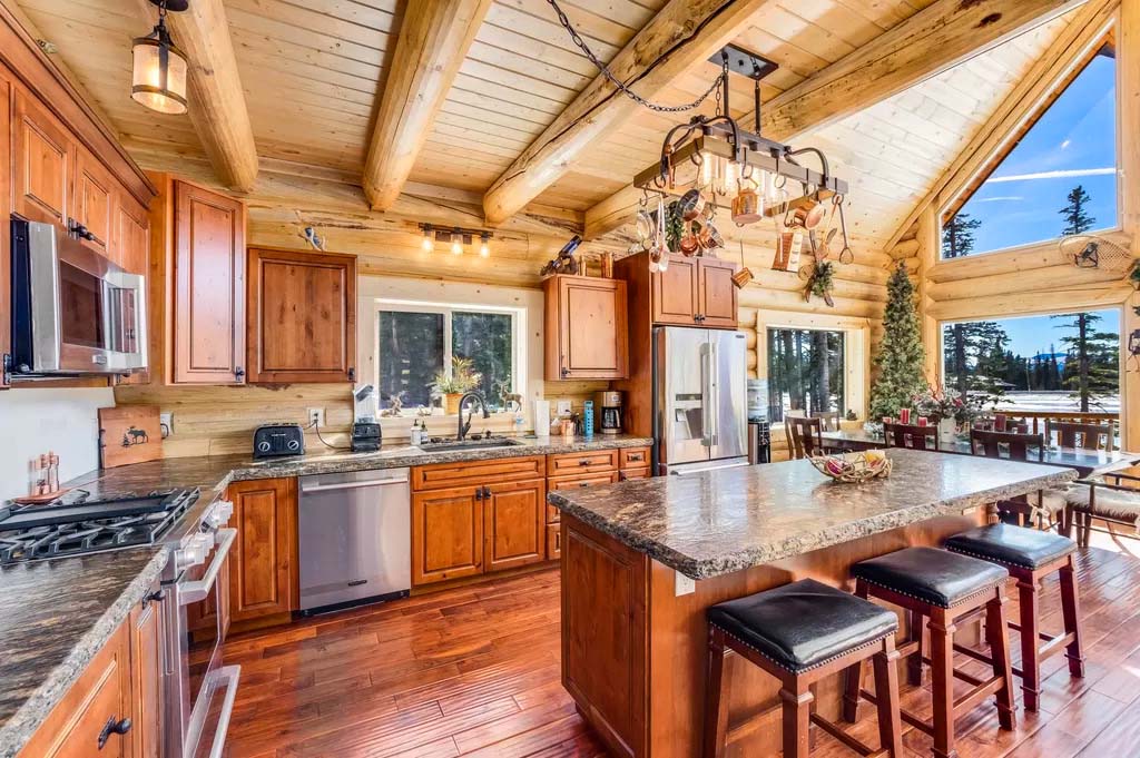 Rustic log cabin kitchen with modern appliances and island
