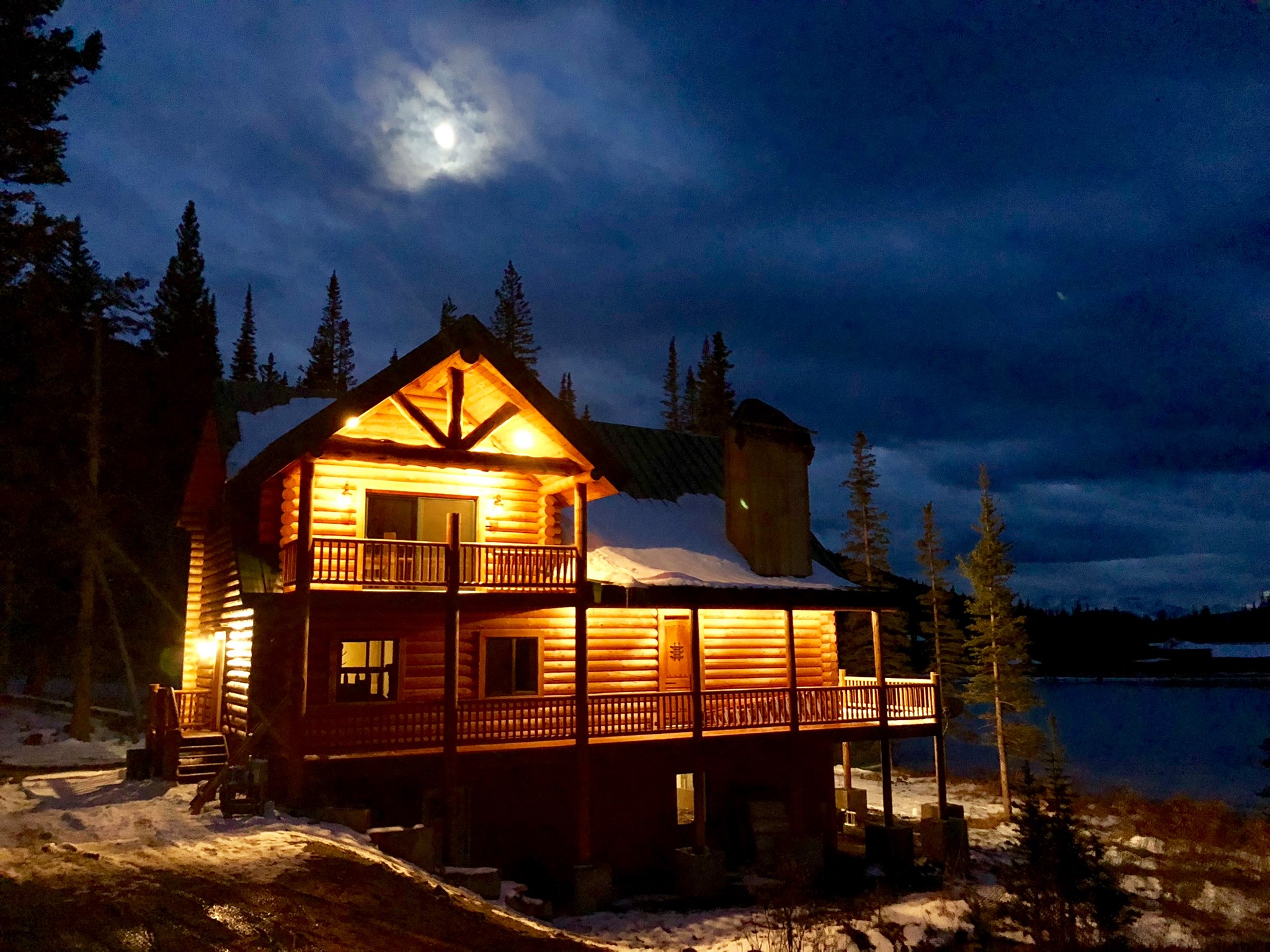 Cozy log cabin illuminated at night in a forested area