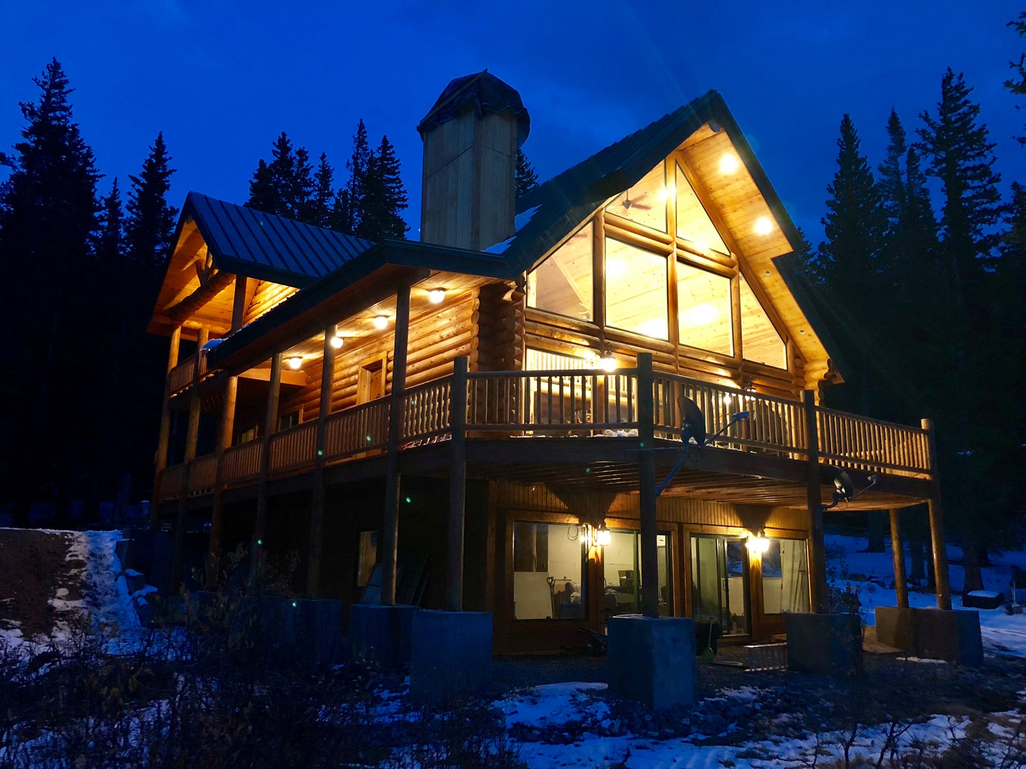 Cozy log cabin illuminated at night in a forested area