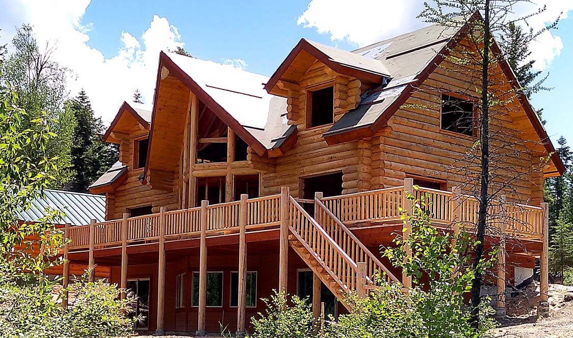 Large wooden cabin in a forest environment under clear skies