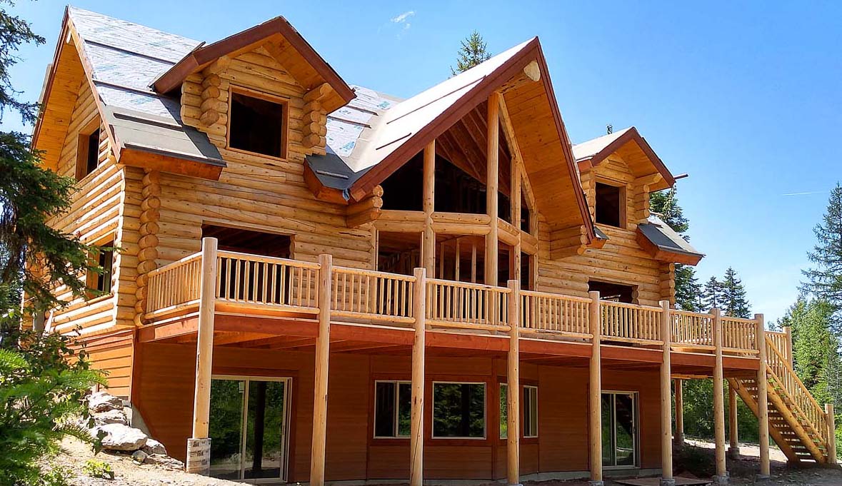 Large wooden cabin in a forest environment under clear skies