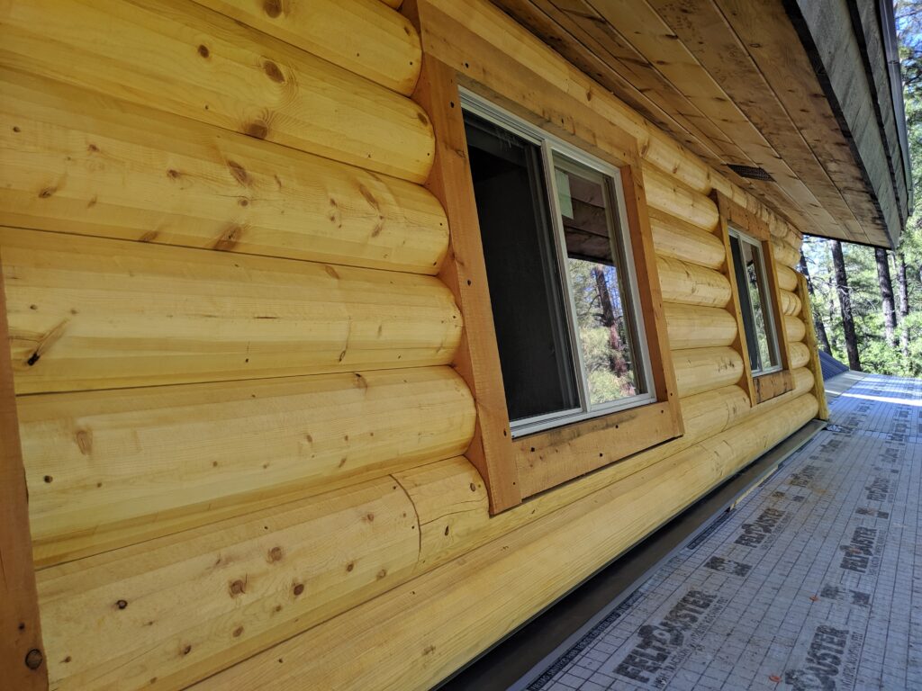 Rustic wooden cabin exterior with window and forest view
