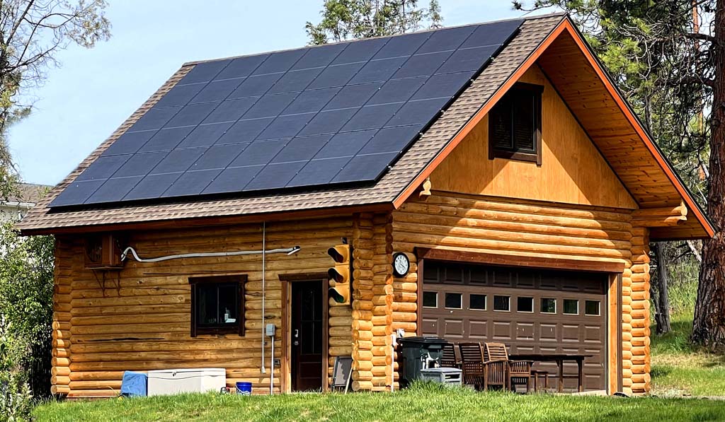 Wooden cabin with rooftop solar panels in lush landscape