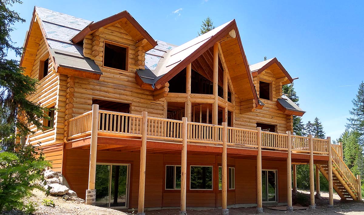 Large rustic wooden cabin surrounded by pine trees