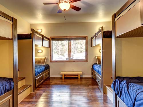 Cozy cabin room with wooden bunk beds and a large window