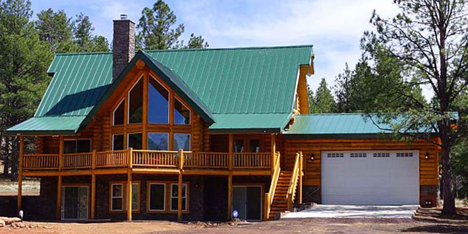 Rustic log cabin with green roof in a wooded area