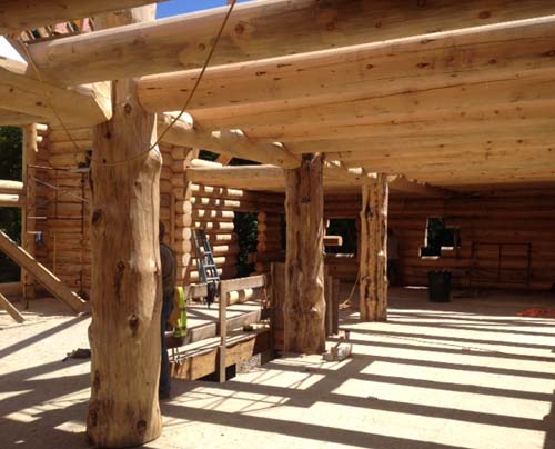 Log cabin under construction with wooden beams and posts