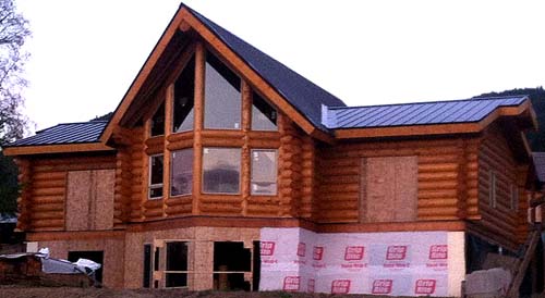 Luxury log cabin under construction with large windows timber