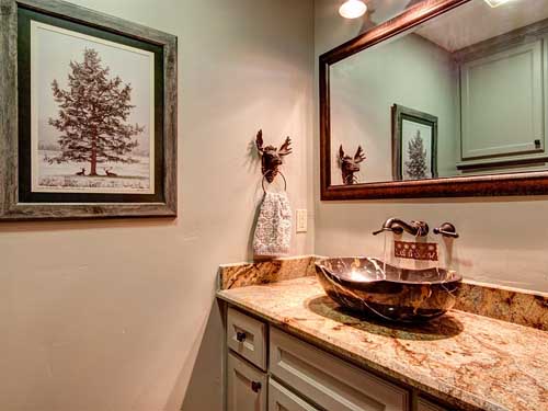Rustic bathroom with granite countertop and wooden mirror frame