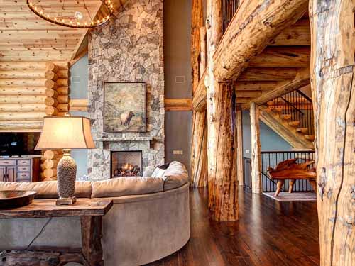 Cozy log cabin living room with rustic stone fireplace