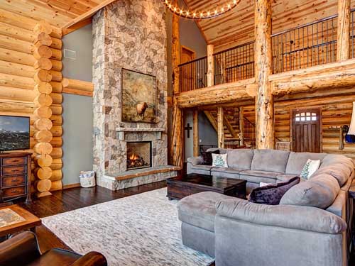 Cozy log cabin living room with rustic stone fireplace
