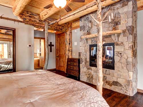 Cozy log cabin living room with rustic stone fireplace