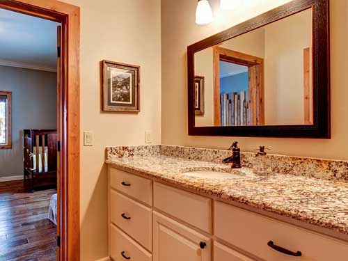 Rustic bathroom with granite countertop and wooden mirror frame