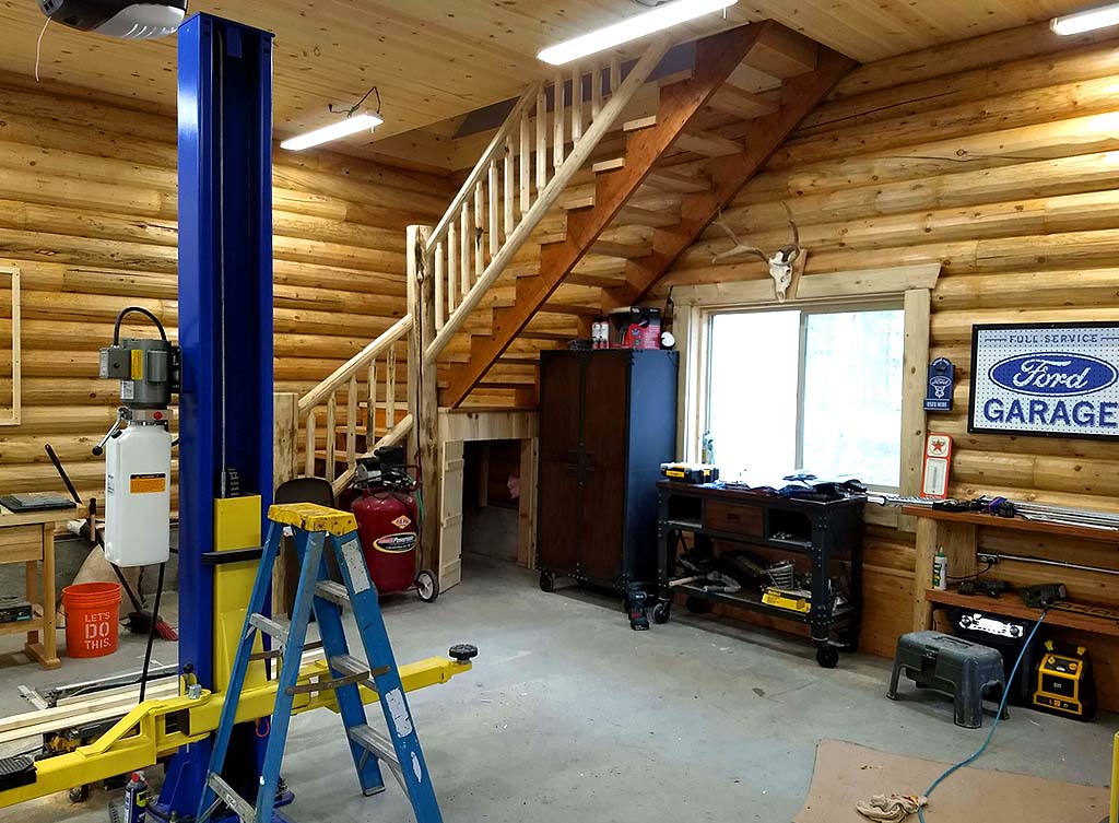 Wooden garage interior with tools ladder and staircase view