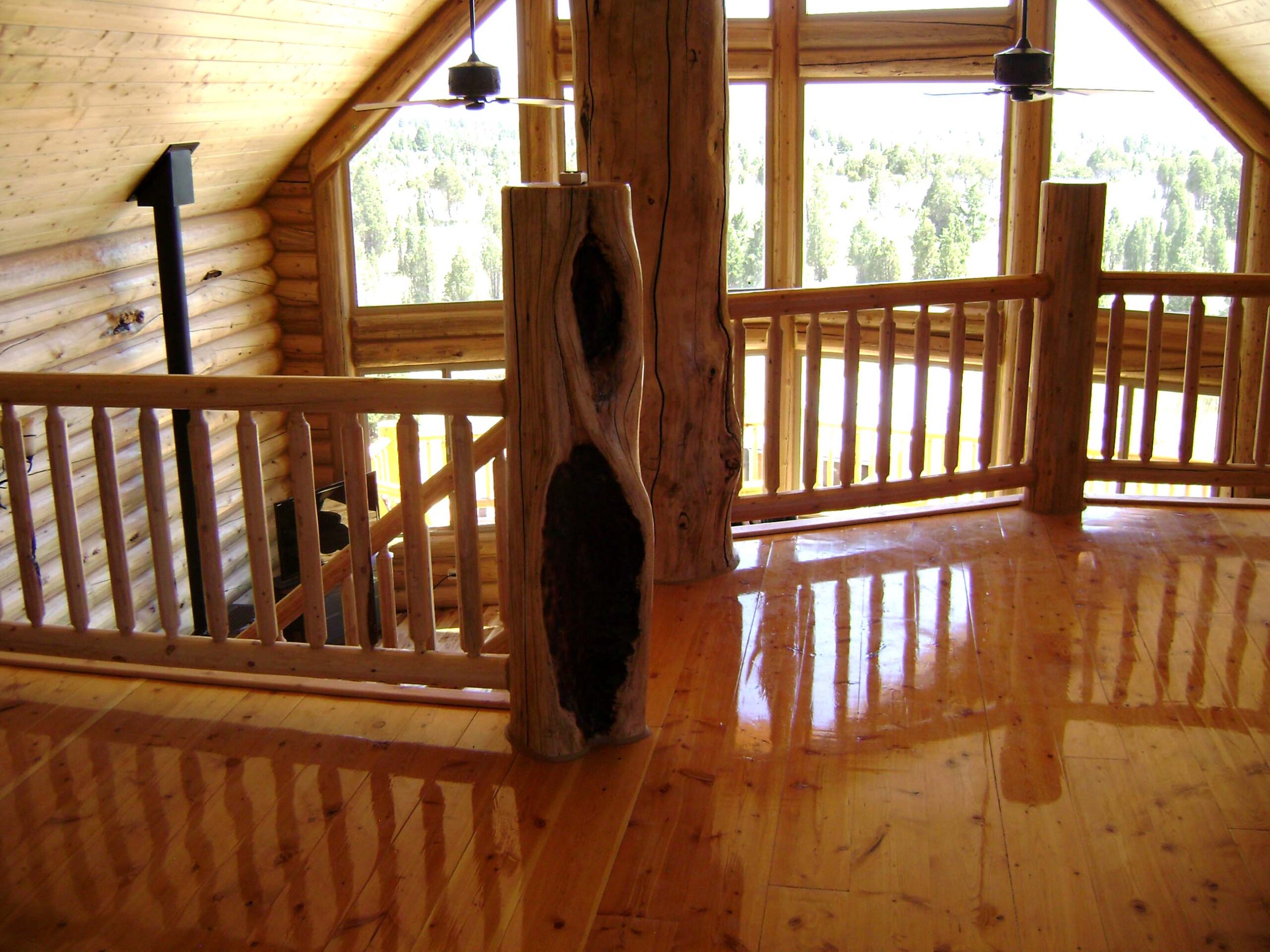 Rustic log cabin interior with wooden floors and large windows