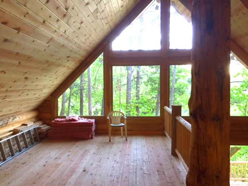 Rustic loft interior with large windows and natural wood beams