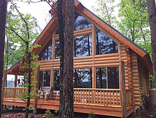 Rustic wooden cabin surrounded by lush green forest trees